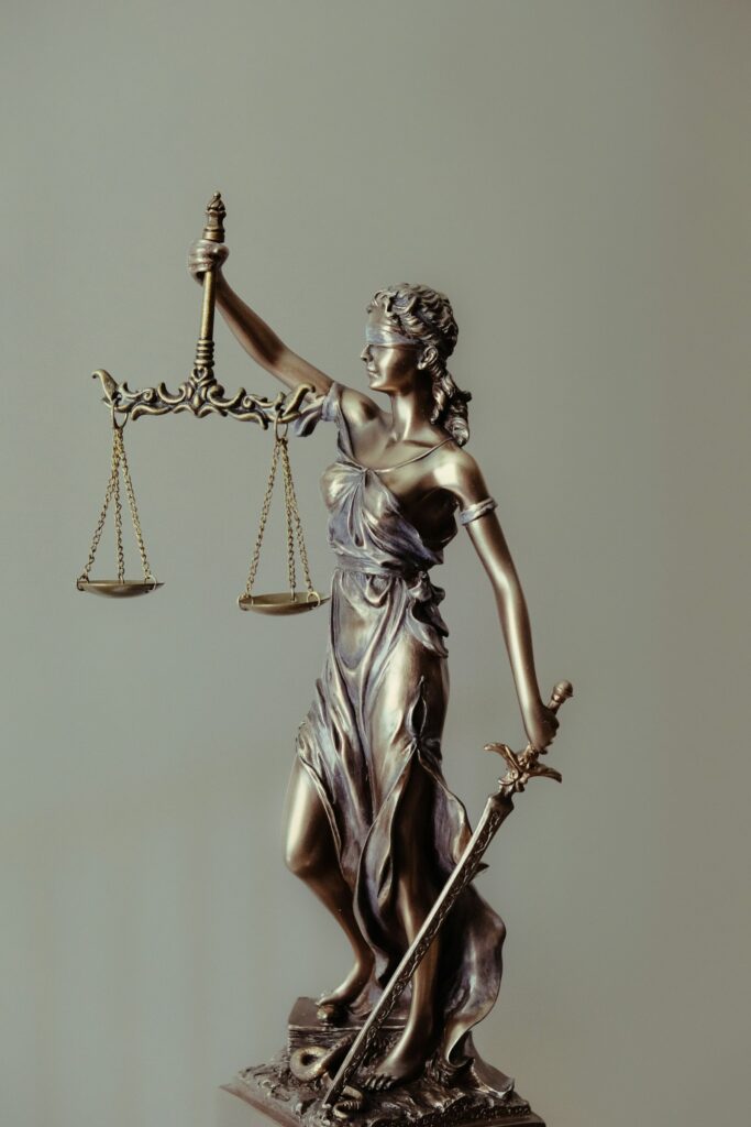 Altın renkli adalet terazisi tutan Justitia heykeli