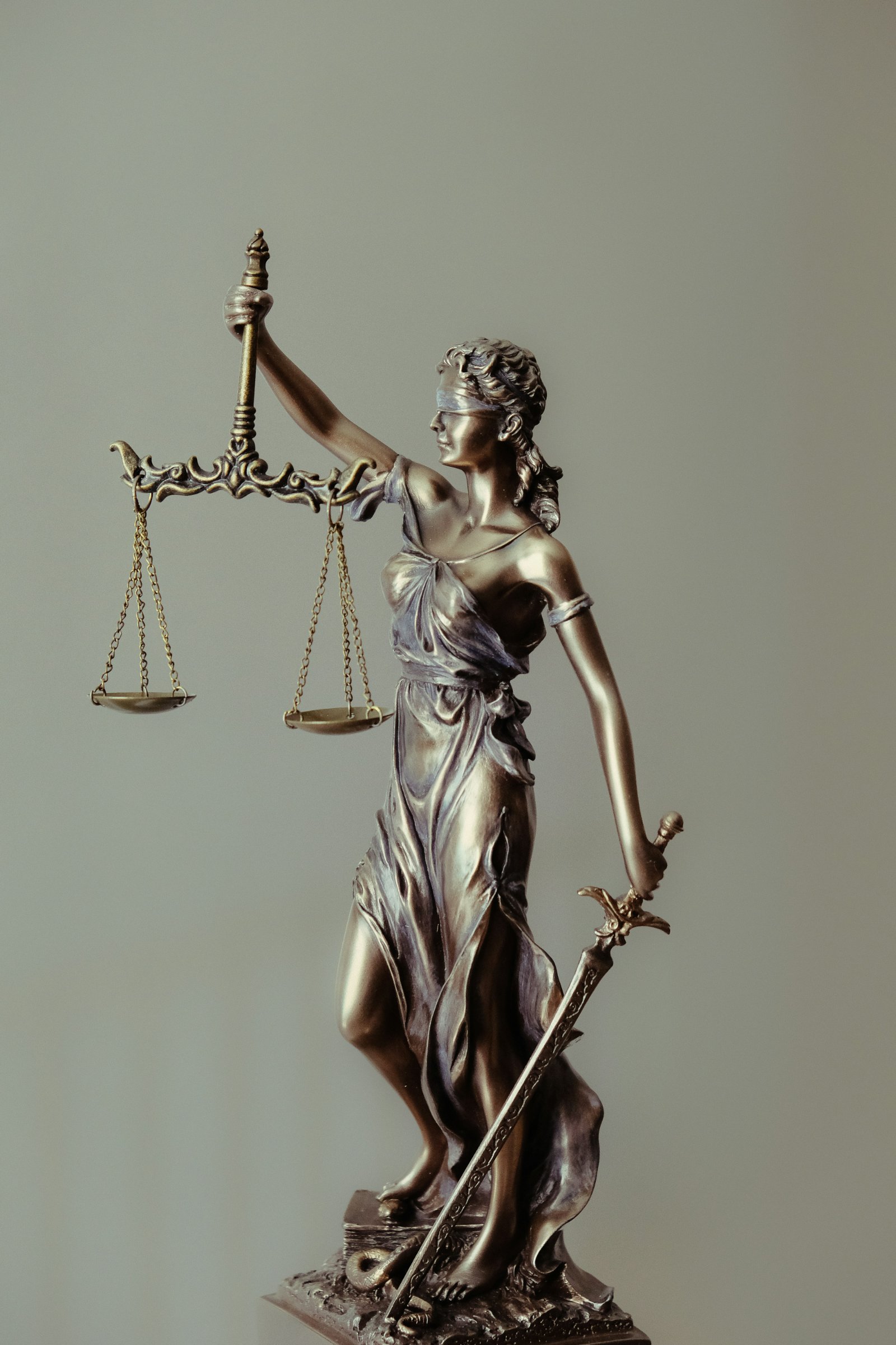 Altın renkli adalet terazisi tutan Justitia heykeli